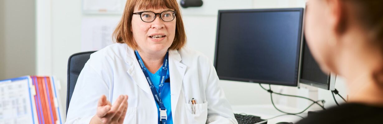 Kuvassa lääkäri ja asiakas keskustelevat