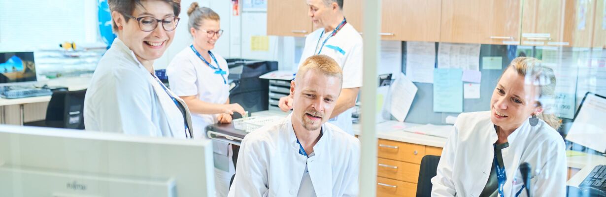 Kuvassa lääkäreitä ja hoitajia kansliassa.