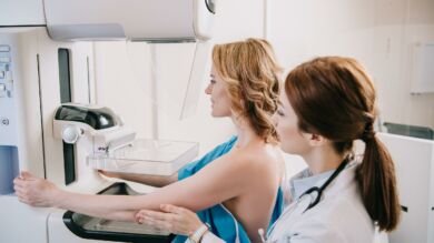 Kuvituskuvassa nainen mammografiassa.