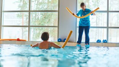 Kuvassa naishenkilö kuntoilee uima-altaassa fysioterapeutin ohjeistuksella.