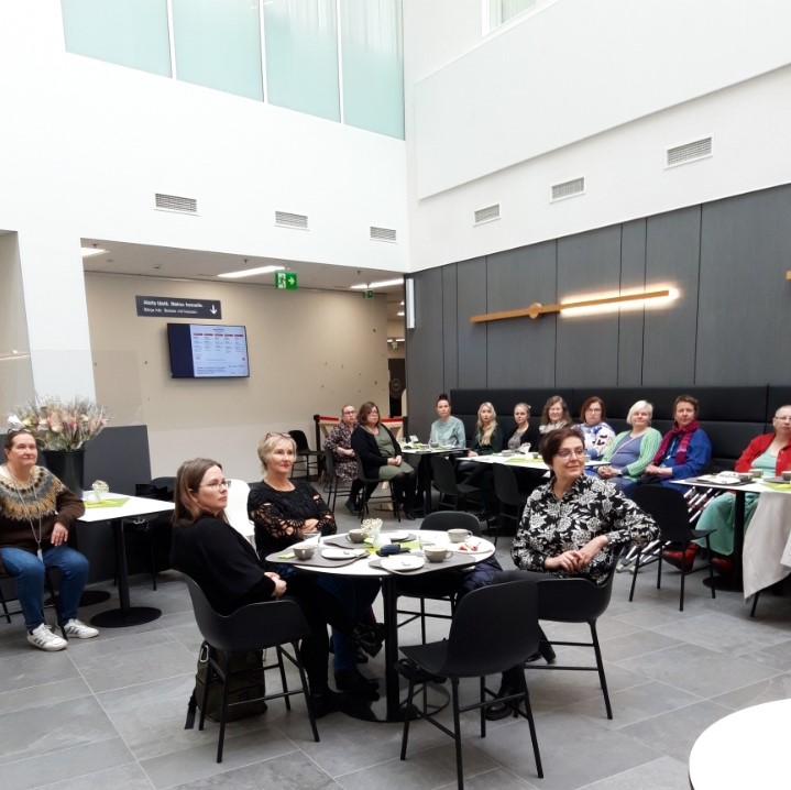 Tarjolla oli kakkua ja kahvia valmistuneille. Kuvassa etulinjan lyhytterapeutiksi valmistuneita keusotelaisia kahvipöytien äärellä.