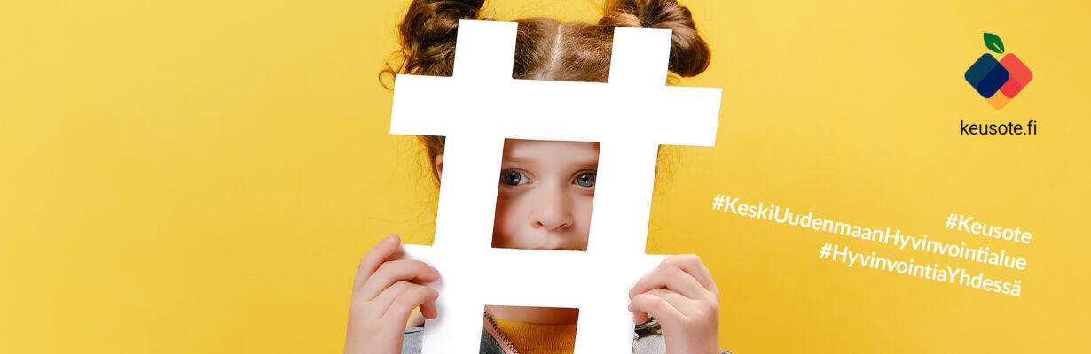 Kuvassa tyttö pitää käsissään isoa hashtag-merkkiä, Keusoten logo sekä tekstit: #Keusote #KeskiUudenmaanHyvinvointialue #HyvinvointiaYhdessä