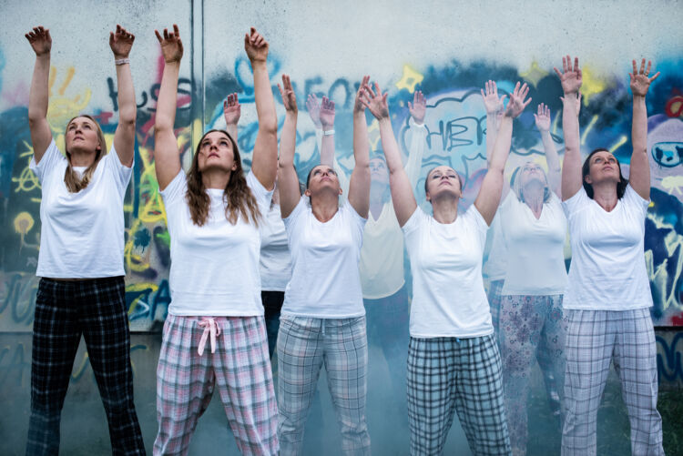 Kuvassa tanssitaidetapahtuman tanssijoita graffitin edessä.