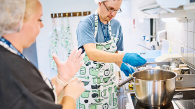 Kuvassa Keusoten työntekijä ja vammaispalvelujen asiakas tekevät ruokaa keittiössä.